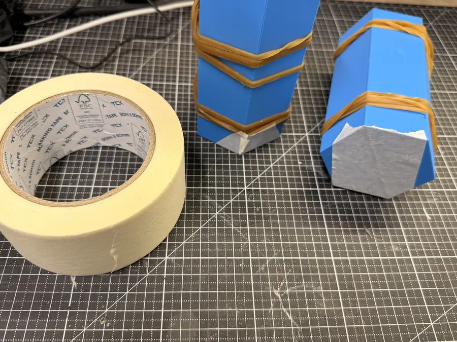 The closed moulds with masking tape over the bottom end, next to a roll of tape.