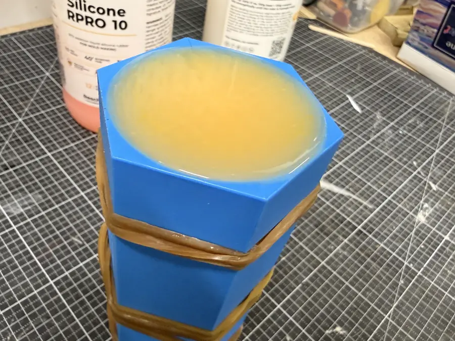 The mould full to the rim with yellow silicone, curing.